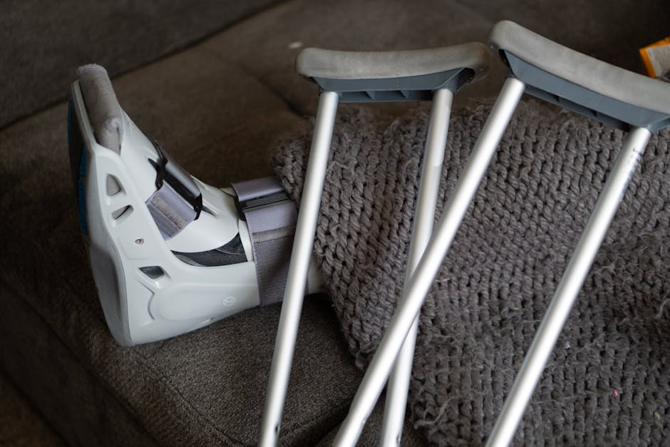 pexels-photo-4067795-4067795 Close-up of an orthopedic boot and crutches on a couch, symbolizing injury recovery at home.
